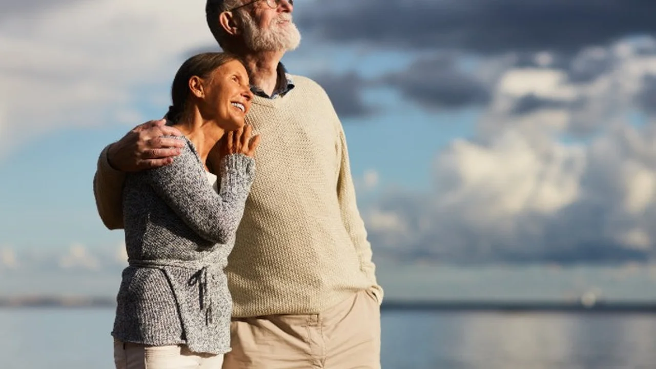 Close up on a plate of mashed potatoes, topped with baked pork chops with cream of mushroom soup, and a side of green beans.