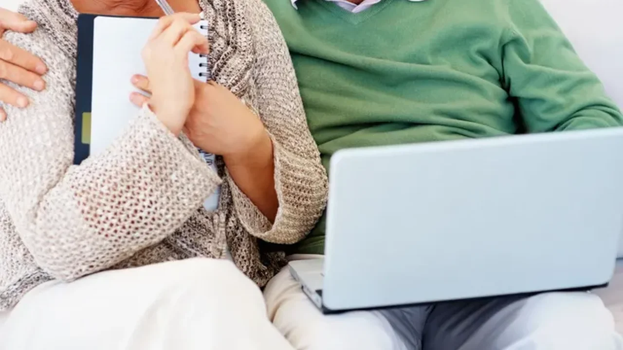 Close up on a plate of mashed potatoes, topped with baked pork chops with cream of mushroom soup, and a side of green beans.